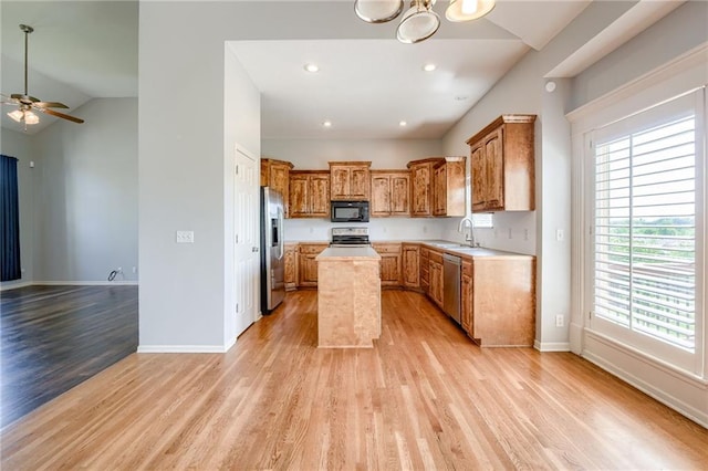 496 S 137th St, Bonner Springs, KS 66012 - kitchen with stainless steel appliances, light wood-style floors, vaulted ceiling, a sink, and a center island