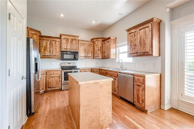 496 S 137th St, Bonner Springs, KS 66012 - kitchen featuring stainless steel appliances, a sink, a kitchen island, light wood-type flooring, and light countertops