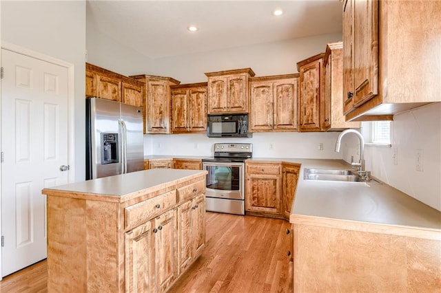 496 S 137th St, Bonner Springs, KS 66012 - kitchen with appliances with stainless steel finishes, a sink, light wood-style floors, a center island, and light countertops