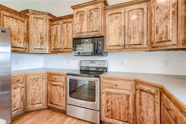 496 S 137th St, Bonner Springs, KS 66012 - kitchen featuring stainless steel appliances, light wood-style floors, brown cabinets, and light countertops
