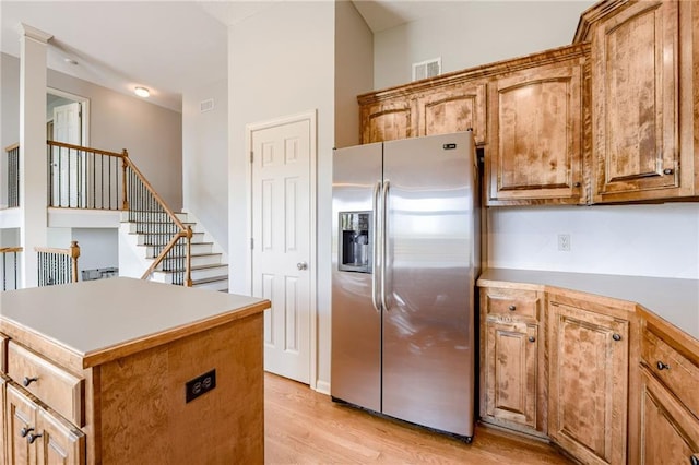 496 S 137th St, Bonner Springs, KS 66012 - kitchen with stainless steel fridge, light wood-type flooring, a center island, and brown cabinets