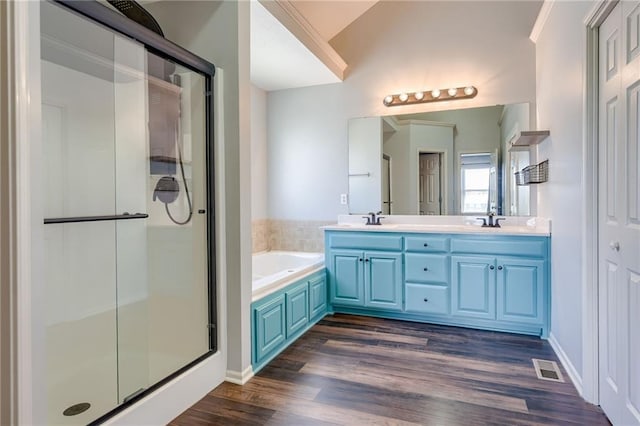 496 S 137th St, Bonner Springs, KS 66012 - full bathroom with a stall shower, a garden tub, lofted ceiling, wood finished floors, and double vanity