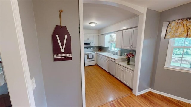 11706 W 69th St, Shawnee, KS 66203 - kitchen with white appliances, light wood-style flooring, light countertops, and plenty of natural light