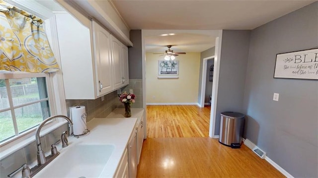 11706 W 69th St, Shawnee, KS 66203 - kitchen featuring a sink, light wood finished floors, white cabinetry, a ceiling fan, and baseboards