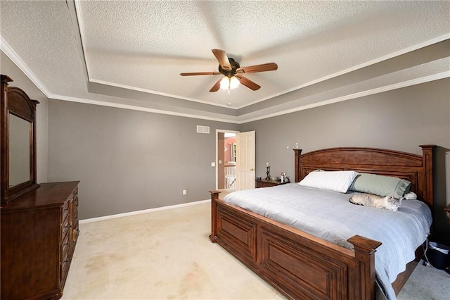bedroom with visible vents, a textured ceiling, a raised ceiling, and light carpet