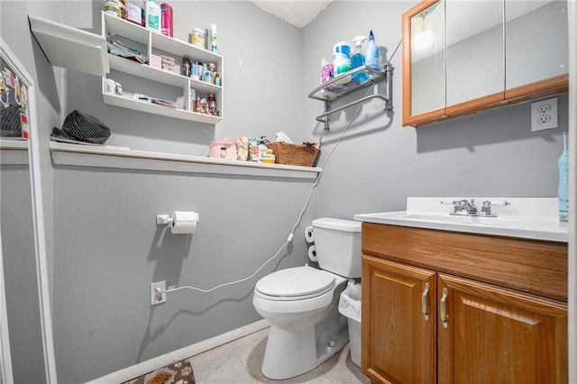 bathroom with toilet, tile patterned floors, and vanity
