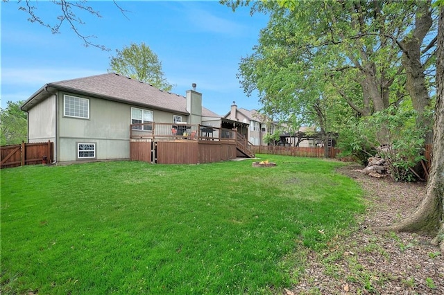 view of yard with stairway, a deck, and a fenced backyard