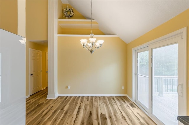 unfurnished dining area featuring light wood-style floors, baseboards, high vaulted ceiling, and a notable chandelier