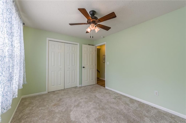 unfurnished bedroom featuring baseboards, carpet, and a closet