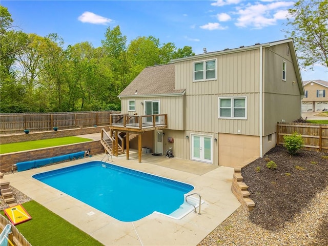 rear view of property with stairs, a wooden deck, a fenced backyard, a patio area, and french doors