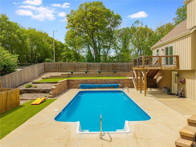 view of swimming pool with a wooden deck, stairway, a fenced in pool, a fenced backyard, and a patio