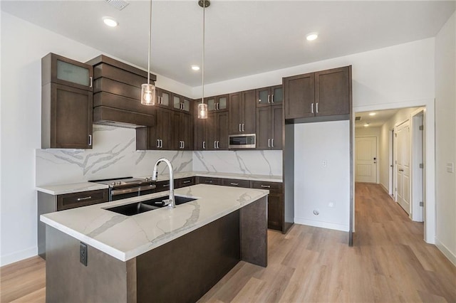 3806-3808 NW 93rd St, Kansas City, MO 64132 - kitchen with appliances with stainless steel finishes, a sink, dark brown cabinets, decorative backsplash, and light wood-style floors