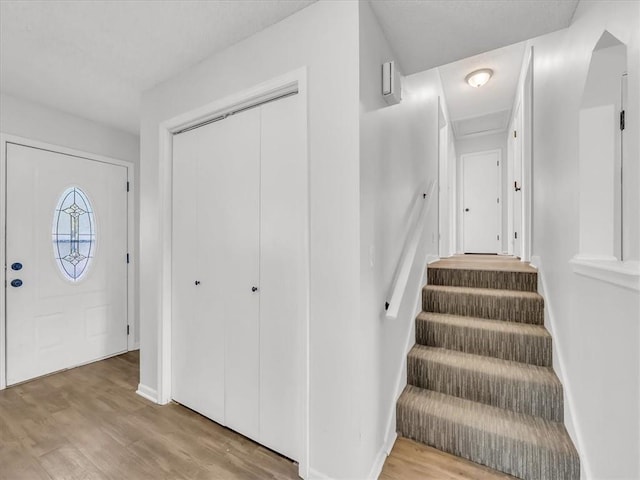 stairway with wood finished floors and baseboards