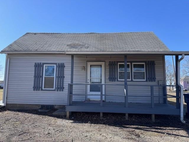 rear view of property featuring a porch and a shingled roof