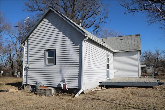 view of home's exterior with a shingled roof and a deck