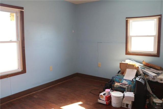 spare room featuring baseboards and wood finished floors