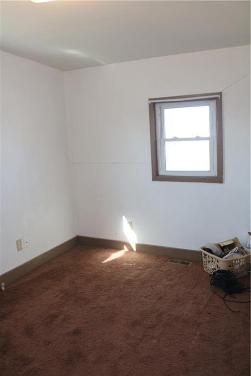 empty room featuring visible vents, carpet flooring, and baseboards