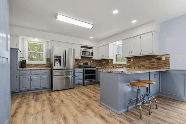 34701 E 235th St, Pleasant Hill, MO 64080 - kitchen with plenty of natural light, stainless steel appliances, a peninsula, and white cabinetry