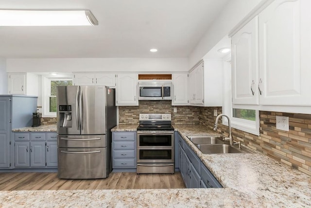 34701 E 235th St, Pleasant Hill, MO 64080 - kitchen featuring stainless steel appliances, white cabinetry, a sink, and plenty of natural light