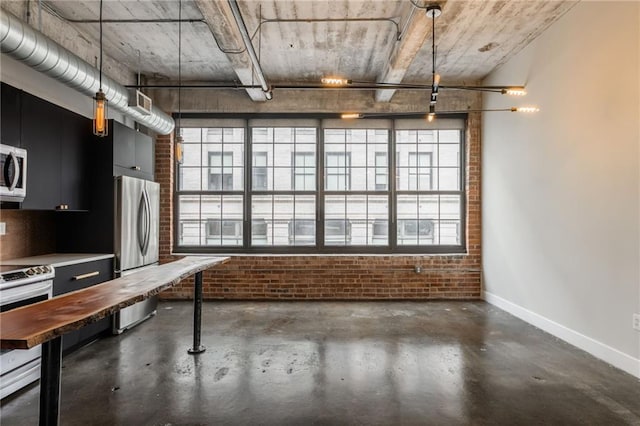 715 May St Unit 328, Kansas City, MO 64105 - kitchen with brick wall, appliances with stainless steel finishes, healthy amount of natural light, dark cabinets, and concrete floors
