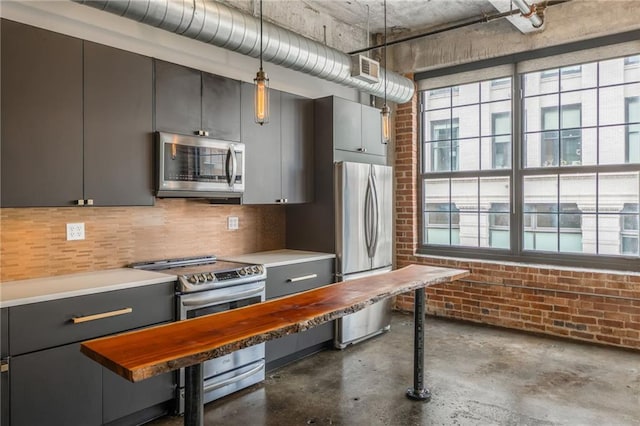 715 May St Unit 328, Kansas City, MO 64105 - kitchen with stainless steel appliances, healthy amount of natural light, concrete floors, brick wall, and decorative light fixtures