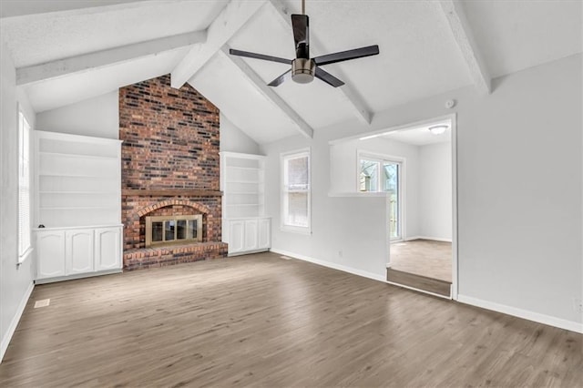 unfurnished living room with lofted ceiling with beams, baseboards, wood finished floors, and ceiling fan