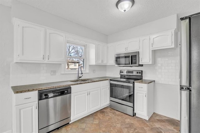 kitchen with white cabinets, a sink, a textured ceiling, and appliances with stainless steel finishes