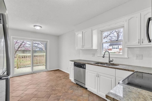 kitchen featuring white cabinets, appliances with stainless steel finishes, a sink, and a textured ceiling