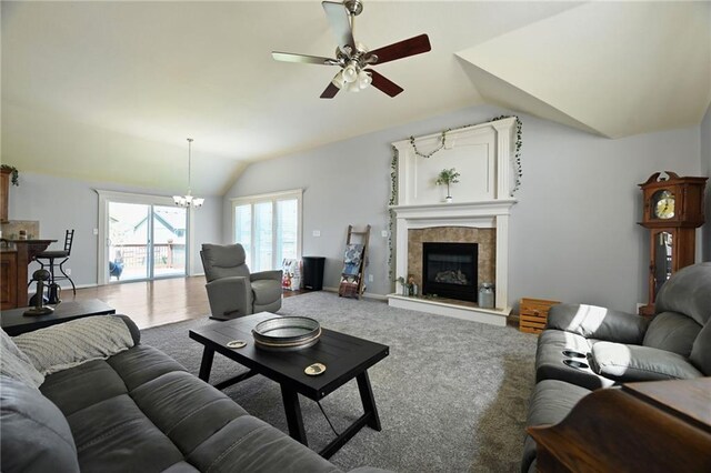 12304 White Oak St, Peculiar, MO 64078 - carpeted living room with ceiling fan with notable chandelier, vaulted ceiling, baseboards, and a fireplace