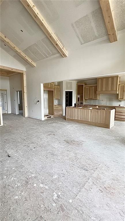 unfurnished living room featuring beamed ceiling and high vaulted ceiling