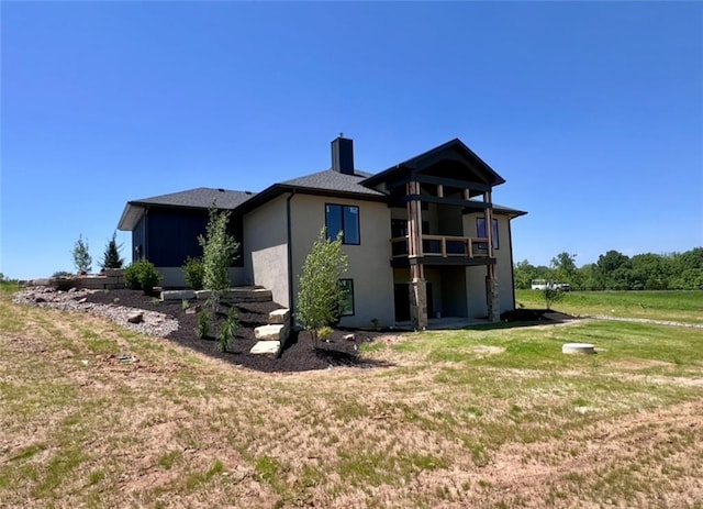 20840 Golden Rd, Linwood, KS 66052 - rear view of property with a chimney, stucco siding, a yard, and a balcony