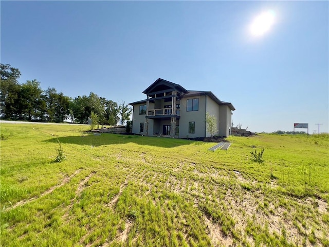20840 Golden Rd, Linwood, KS 66052 - rear view of property with a balcony, a lawn, and stucco siding