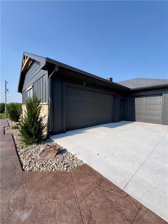 20840 Golden Rd, Linwood, KS 66052 - view of home's exterior with concrete driveway, a garage, and stone siding