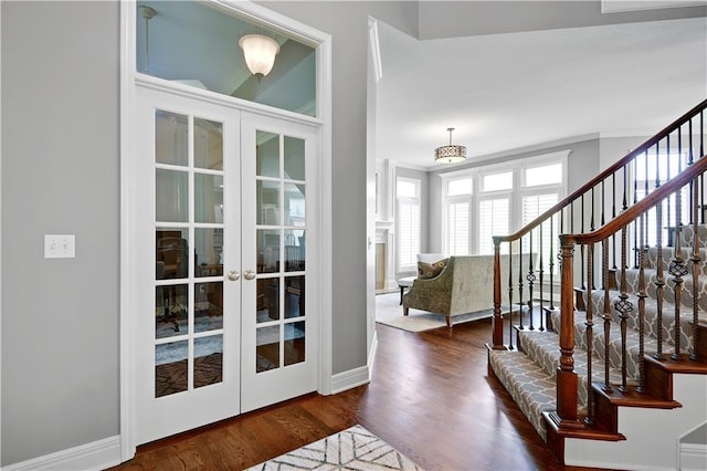 entrance foyer featuring baseboards, french doors, and wood finished floors