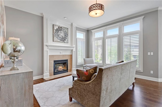 living room with crown molding, baseboards, a fireplace, and dark wood-type flooring