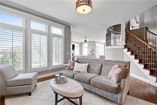 living room with baseboards, a ceiling fan, stairs, and wood finished floors