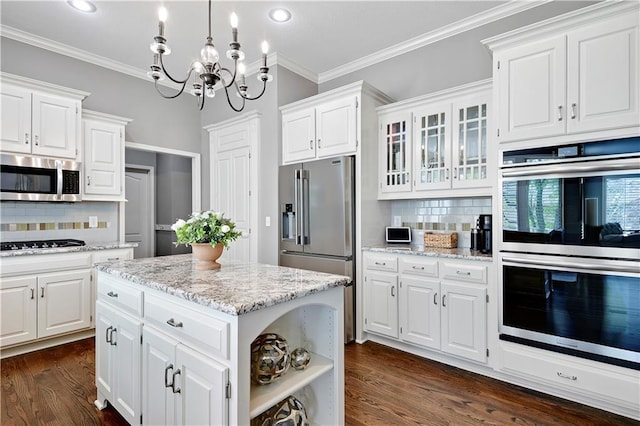 kitchen featuring stainless steel appliances, dark wood finished floors, white cabinetry, and tasteful backsplash