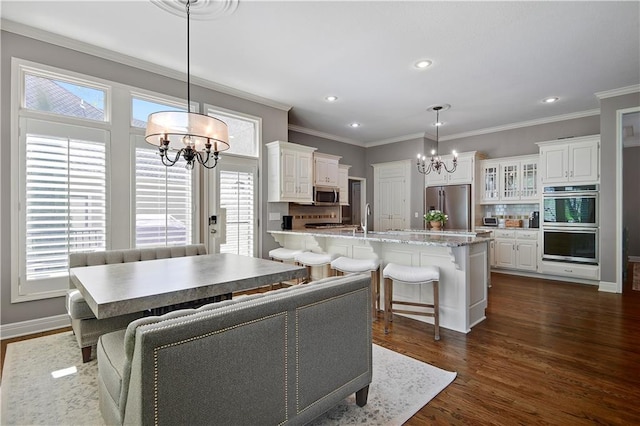 interior space featuring crown molding, dark wood finished floors, a notable chandelier, and a healthy amount of sunlight