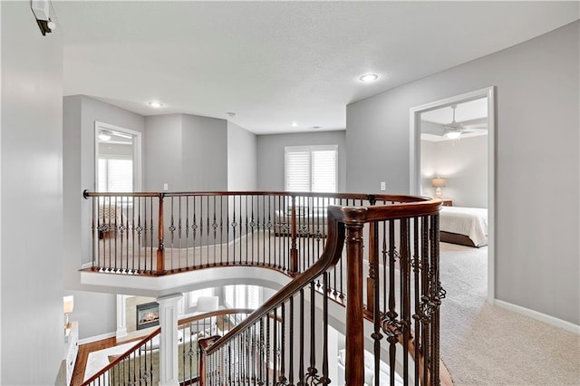 corridor with recessed lighting, baseboards, an upstairs landing, and carpet