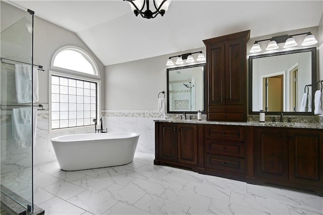 full bathroom featuring a sink, marble finish floor, a freestanding tub, and a shower stall