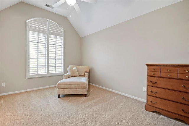 living area with baseboards, ceiling fan, light carpet, and lofted ceiling