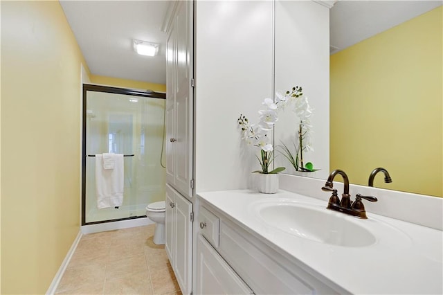bathroom featuring vanity, tile patterned flooring, toilet, baseboards, and a shower stall