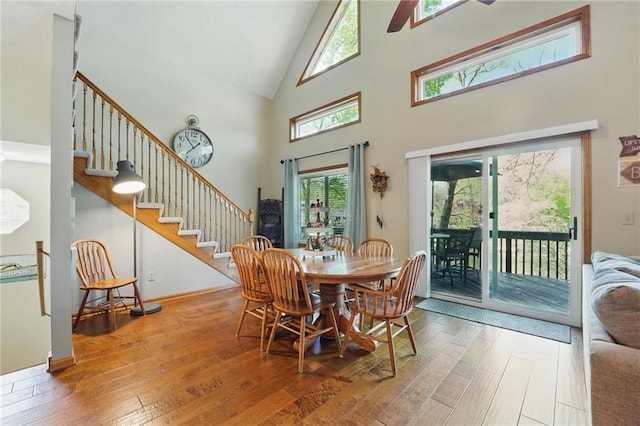 62 Beach Dr, Lake Tapawingo, MO 64015 - dining space with high vaulted ceiling, stairs, hardwood / wood-style flooring, and healthy amount of natural light