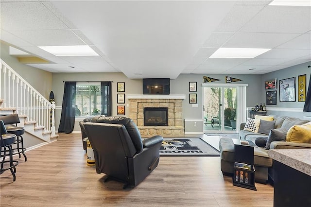 62 Beach Dr, Lake Tapawingo, MO 64015 - living area featuring a drop ceiling, light wood-type flooring, stairway, a fireplace, and baseboards