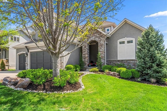 view of front of property with a front yard, stucco siding, driveway, and stone siding