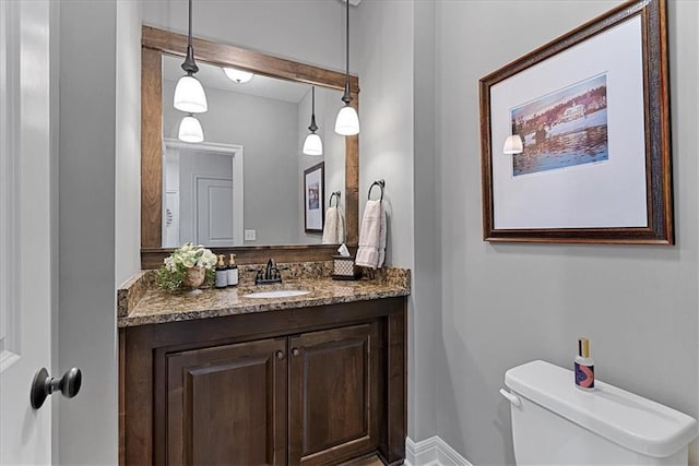 half bathroom with vanity and toilet
