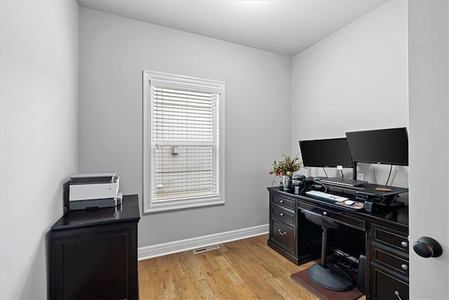 home office with visible vents, light wood-style flooring, and baseboards