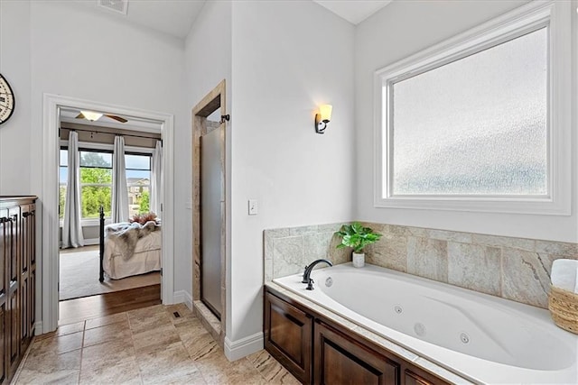 bathroom featuring a jetted tub, baseboards, visible vents, and a shower stall
