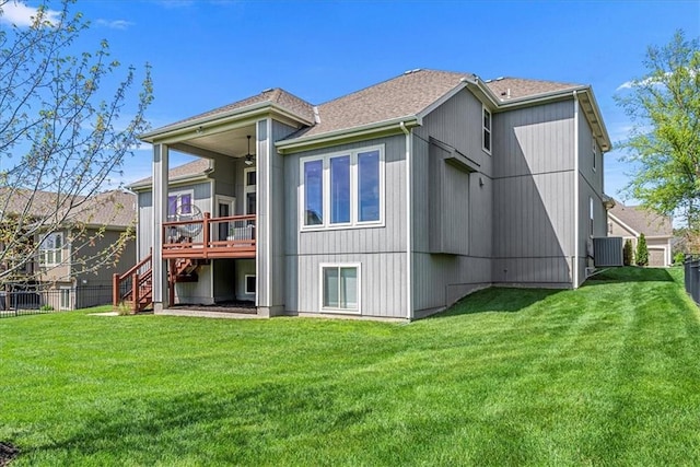 rear view of property featuring fence, a wooden deck, ceiling fan, and a yard