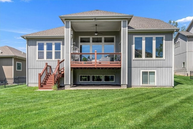 back of house featuring fence, stairs, ceiling fan, and a yard